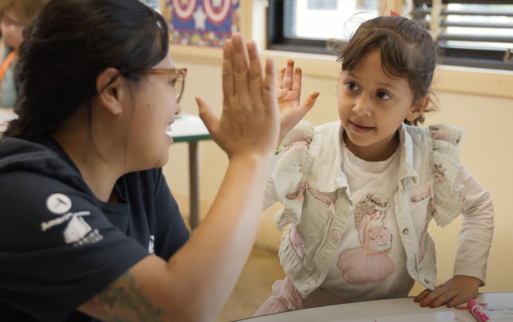 A woman giving a high five to a girl.